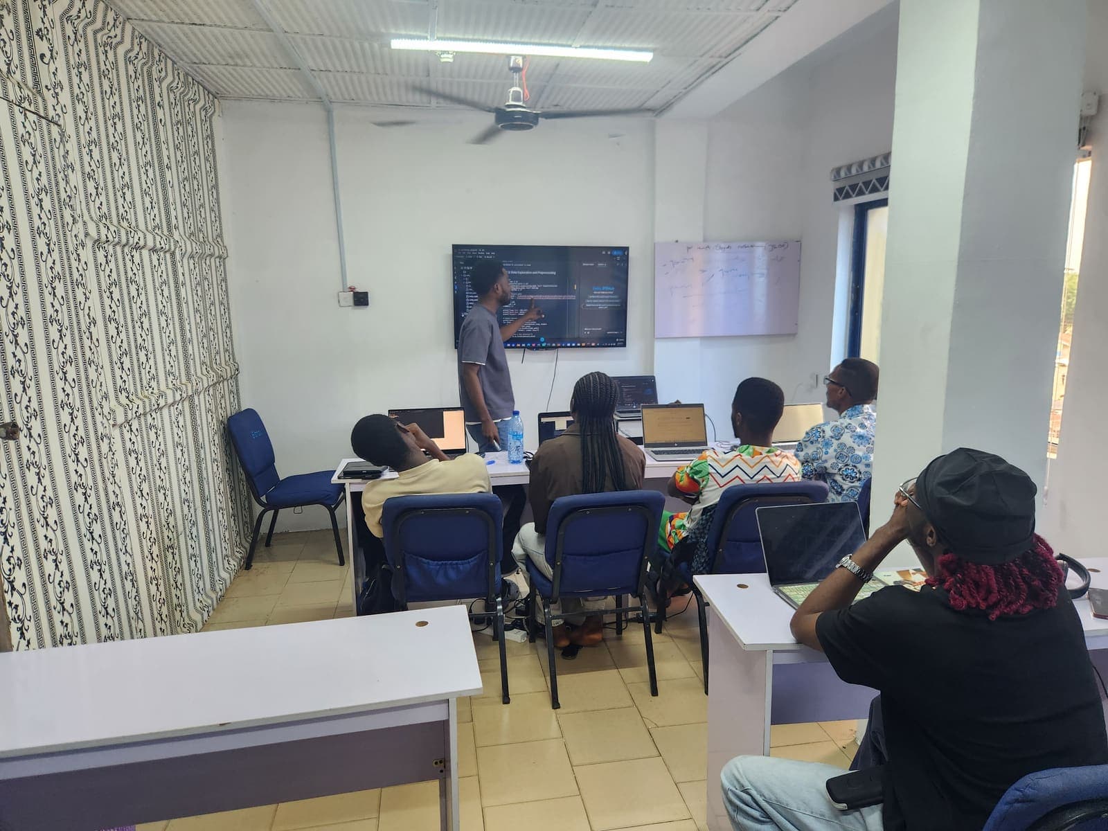 An instructor walking a class through a data project on the wall-mounted screen.